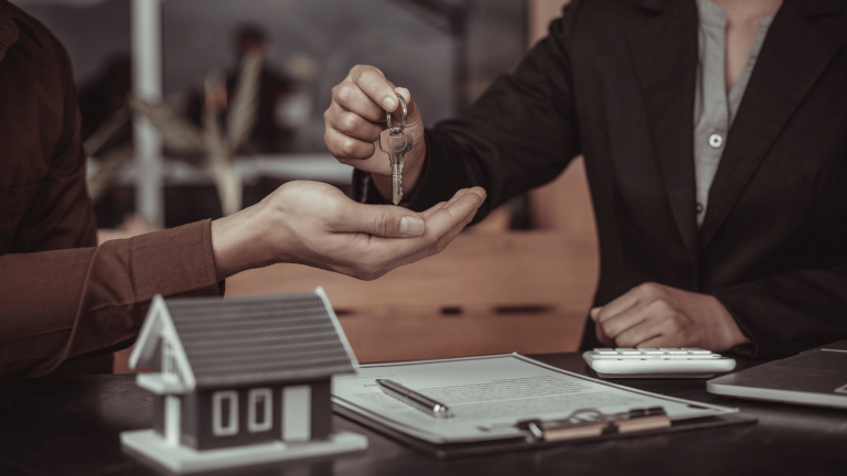 Model house and keys on a desk during a signing