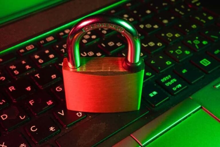 Red padlock on a green-lit laptop keyboard