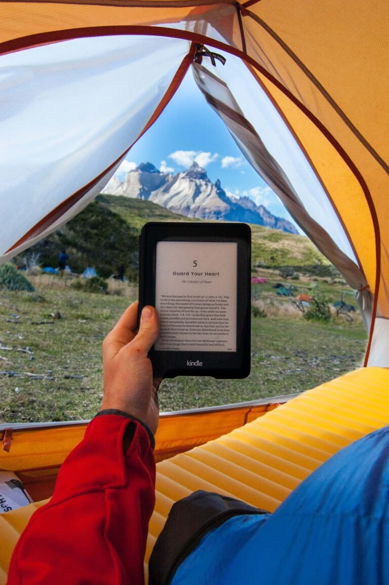 Person reading an e-reader in a tent