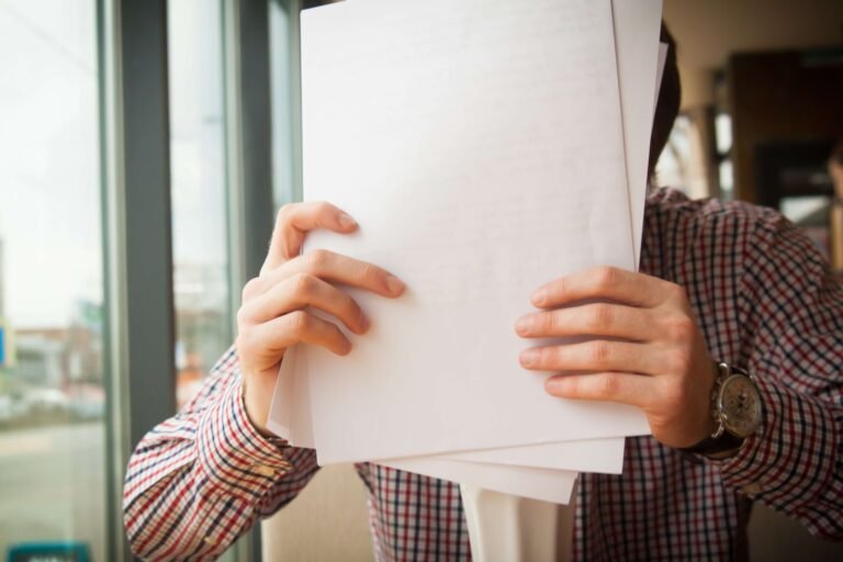 Person holding blank sheets of paper