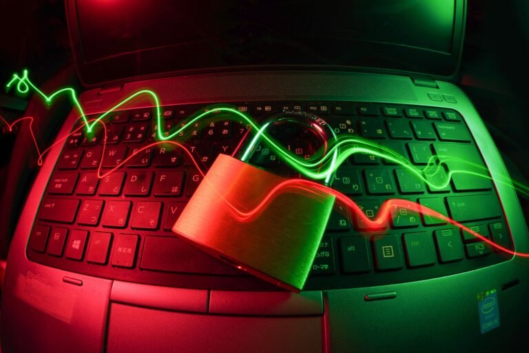 Laptop keyboard lit red and green with a falling chart line