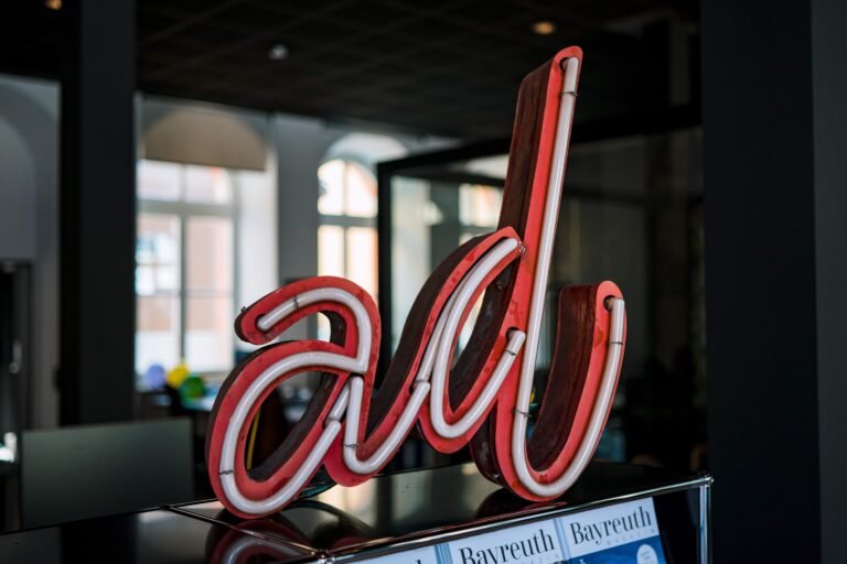 Neon "ad" sign glowing in a dark room