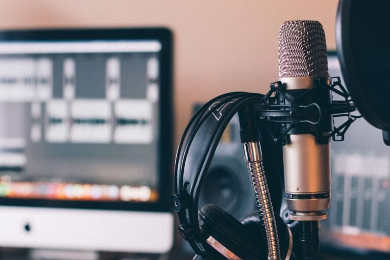 Studio microphone and headphones in front of a computer screen