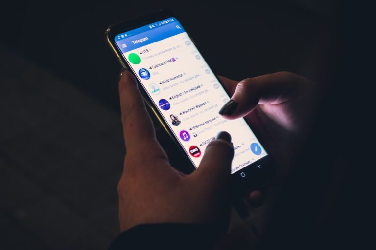 Hand holding a smartphone with the Telegram app open