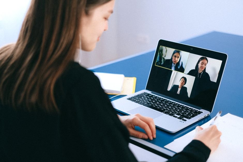 Remote team member taking notes during video conference call