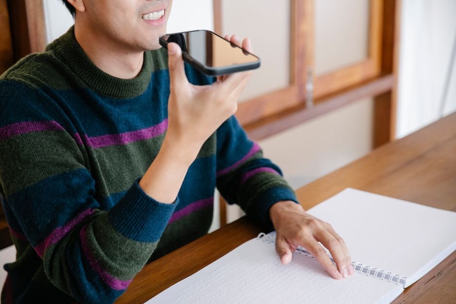 Team member recording voice notes on smartphone for daily standup