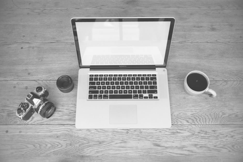 Laptop and coffee on desk with business graphics on screen