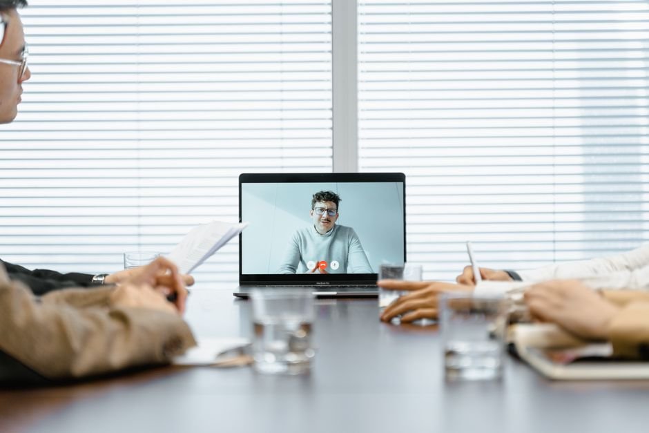 Business team participating in online video meeting with laptops