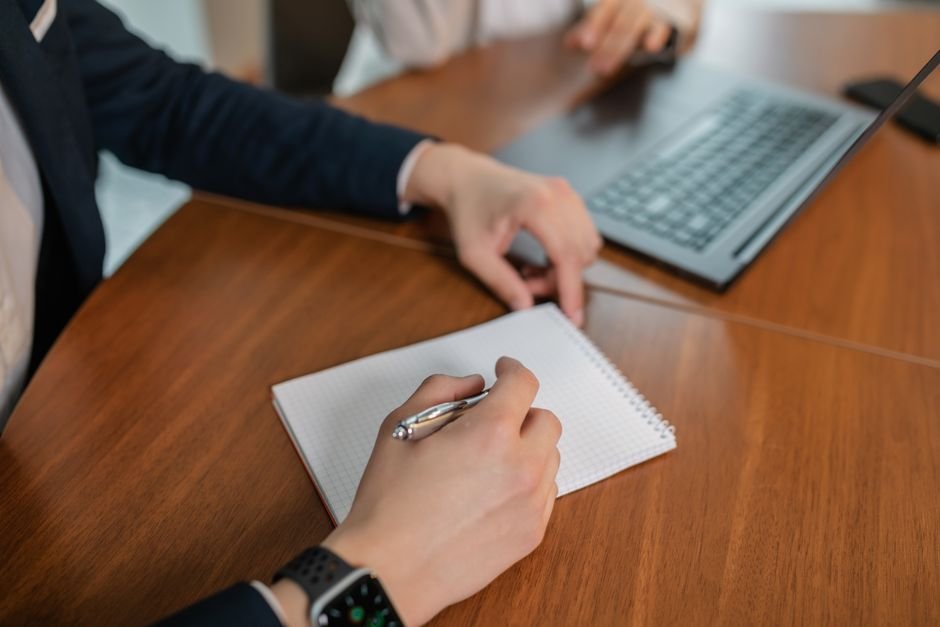 Person working on laptop with meeting agenda and notes displayed on screen