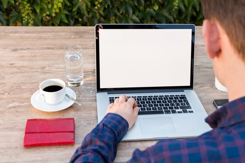 Solopreneur working at desk with laptop using AI prompts for daily tasks