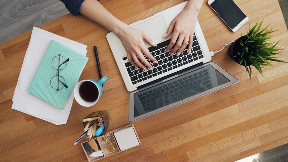 Freelancer writing proposal using AI tools on laptop at home office desk