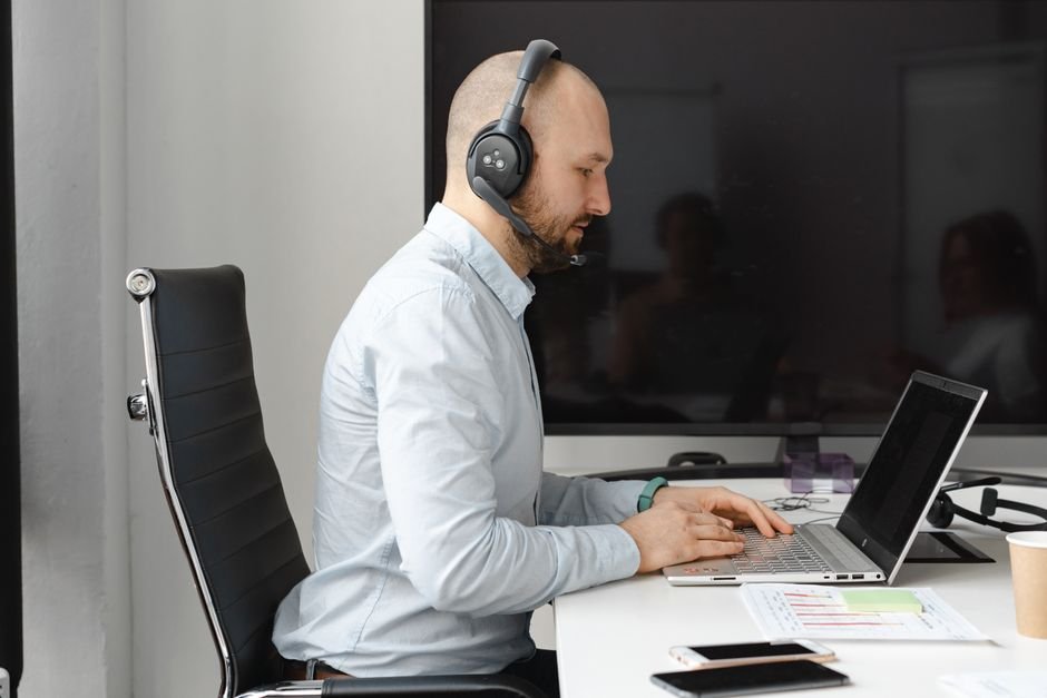 Freelancer using headphones and laptop for audio transcription work