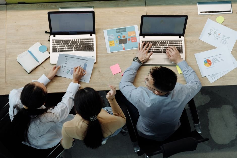 Team members collaborating on laptop reviewing workflow process