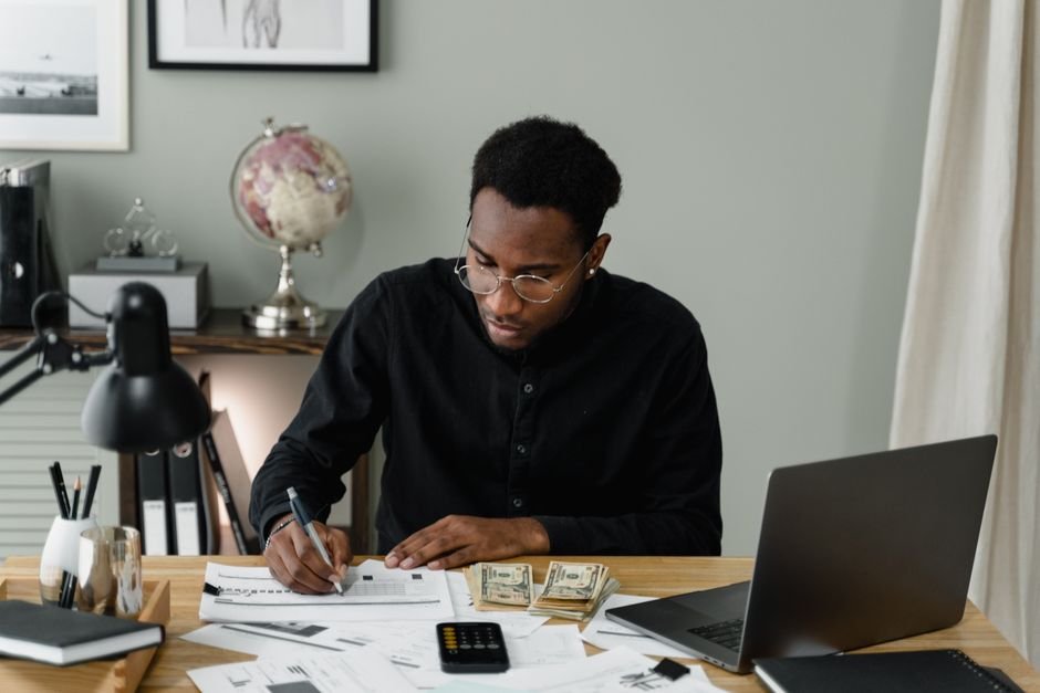 Freelancer managing subscription costs and tracking AI tool usage on laptop