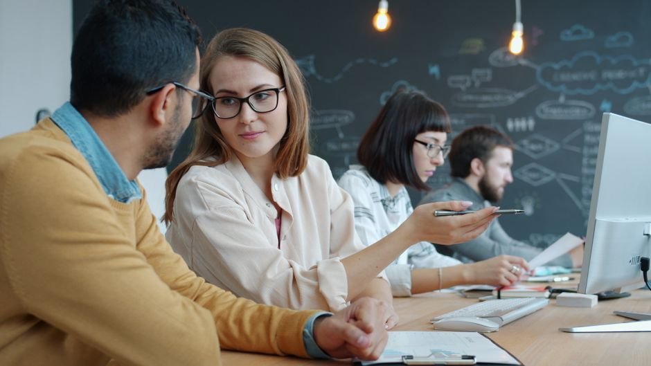 Small business team testing new AI tool together on computer