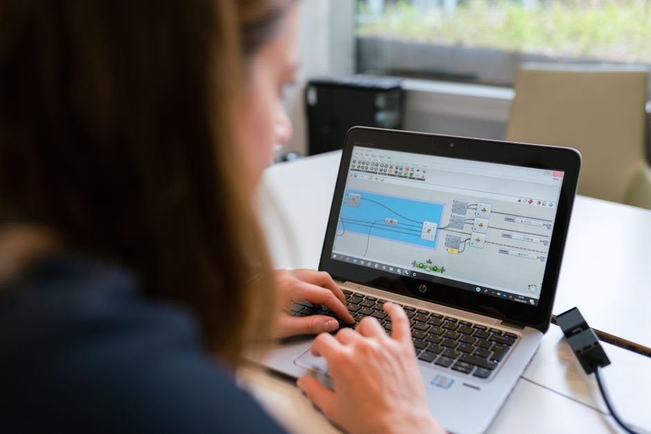 Software developer tracking bugs on laptop with sticky notes on desk