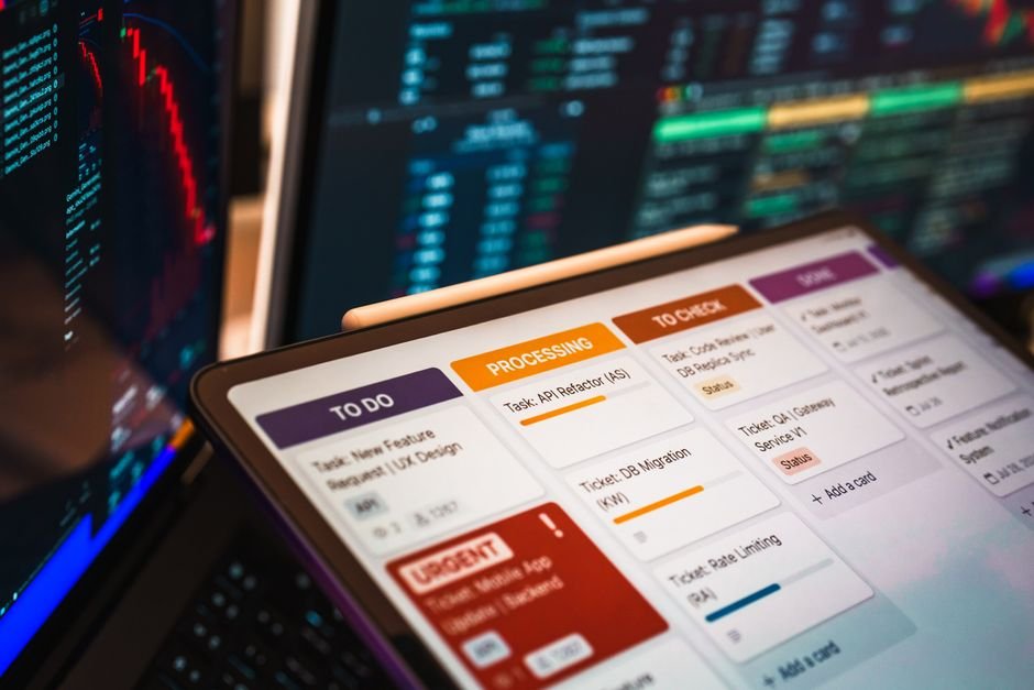 Close-up of a laptop screen displaying a kanban board with columns and task cards