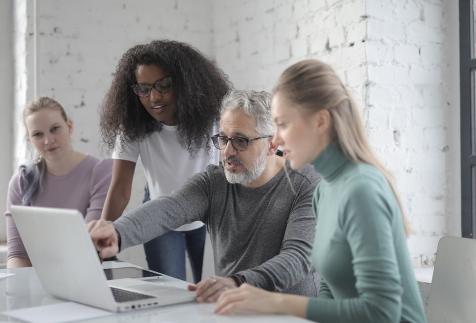 Small team reviewing daily standup notes together on a laptop