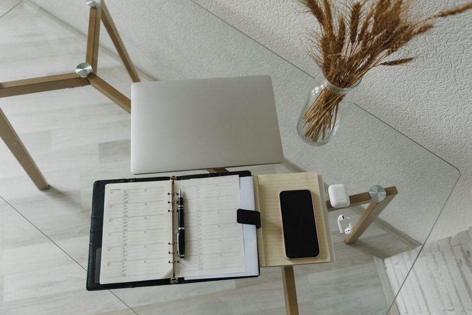 Clean workspace with planner and laptop showing project tracker and deadlines