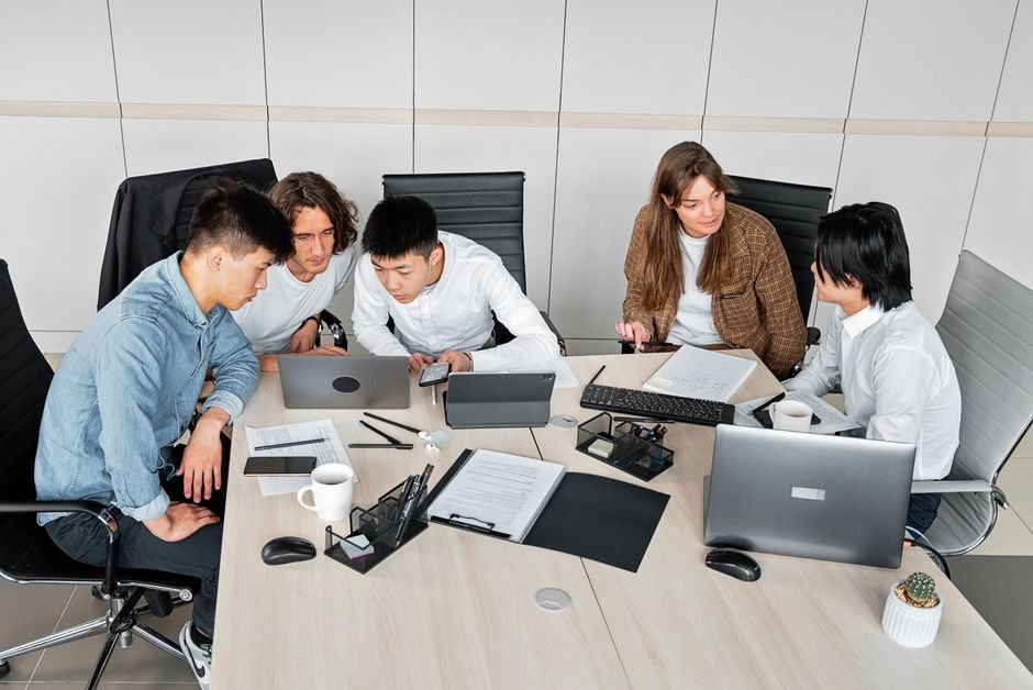 Team members working together on shared documentation at a laptop