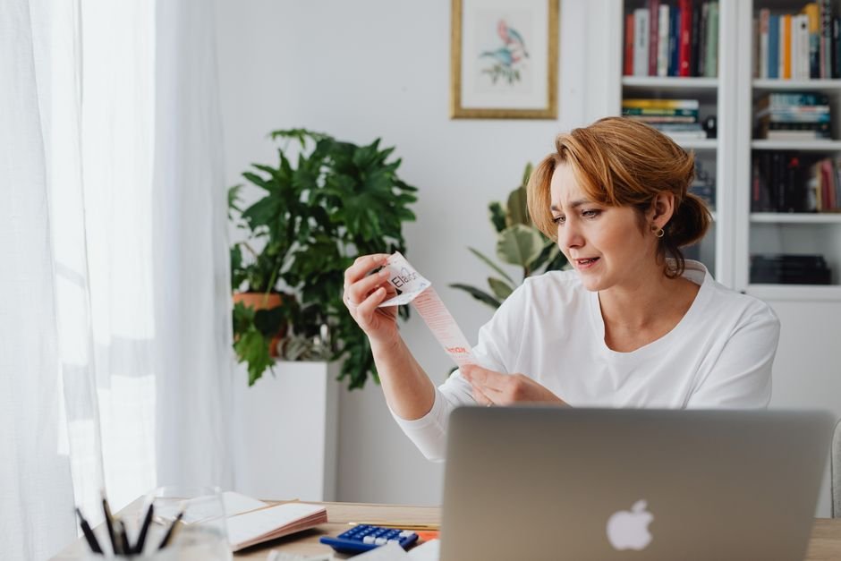 Freelancer auditing monthly subscription costs on laptop to reduce AI tool spending