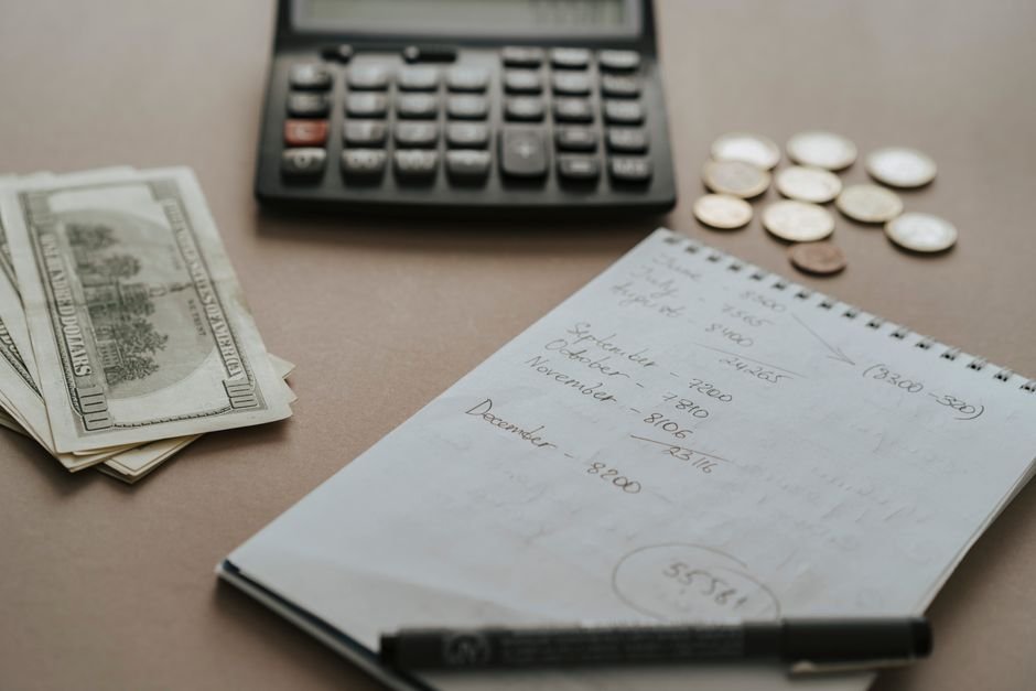 Small business owner planning AI tool budget with notebook and calculator