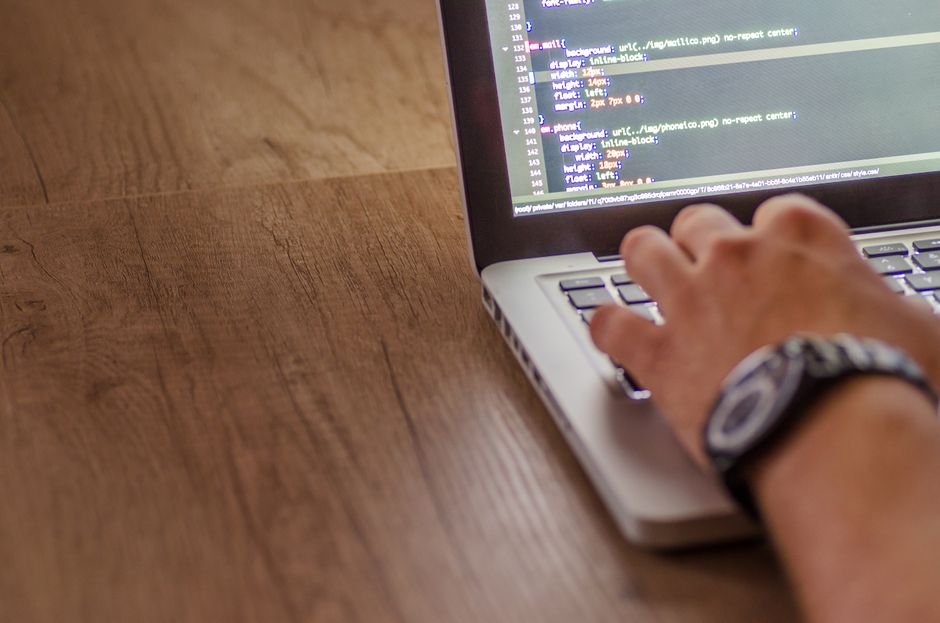 Developer working on sprint tasks at desk with code on screen